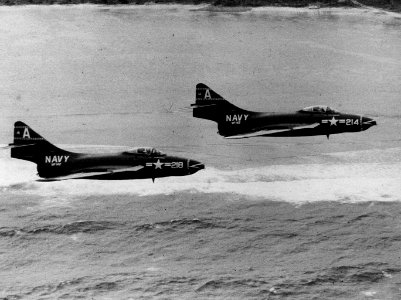 Grumman F9F-6 Cougars of VF-142 in a low-level flight over the coast of Guam, in January 1956 (NNAM.1996.253.7411.033)