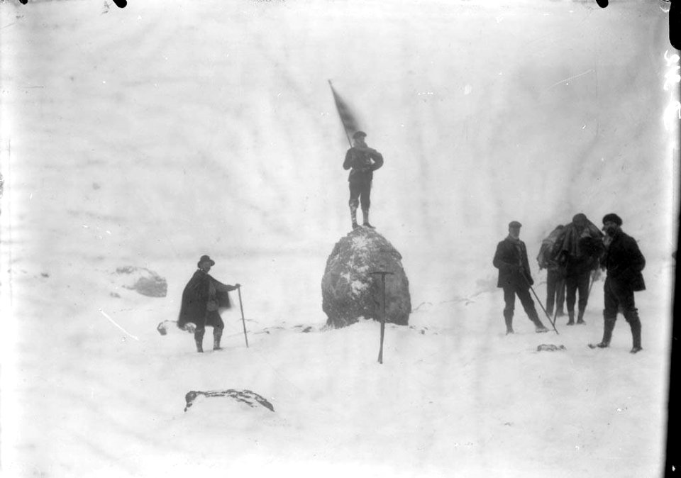 Grup d'alpinistes un damunt d'una pedra amb una senyera a la frontera del port de Bujaruelo