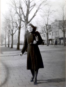 Hannie Schaft in winterjas met tasje op lange laan onder kale bomen photo