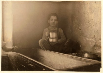 Jo Benevidos, 5 Merion St. Curled up in a doffing box, eating his lunch. LOC cph.3a20281
