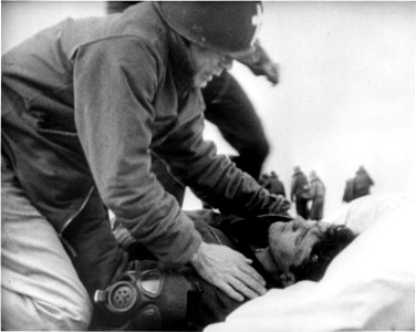 Joseph T. O'Callahan gives last rites to an injured crewman aboard USS Franklin (CV-13), 19 March 1945 photo