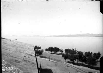 La ria de Vigo i a la riba un edifici i un passeig amb arbres