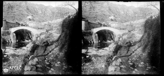 La riera de Beget amb un pont en primer terme i el poble de Beget al fons