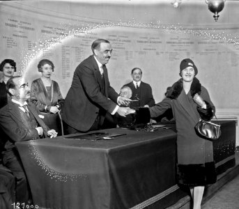 M. Jacques Worth remet le prix à Mlle Legouais, meilleure ouvrière (cérémonie à la chambre syndicale de la couture, rue Montesquieu) - (photographie de presse) - (Agence Rol)
