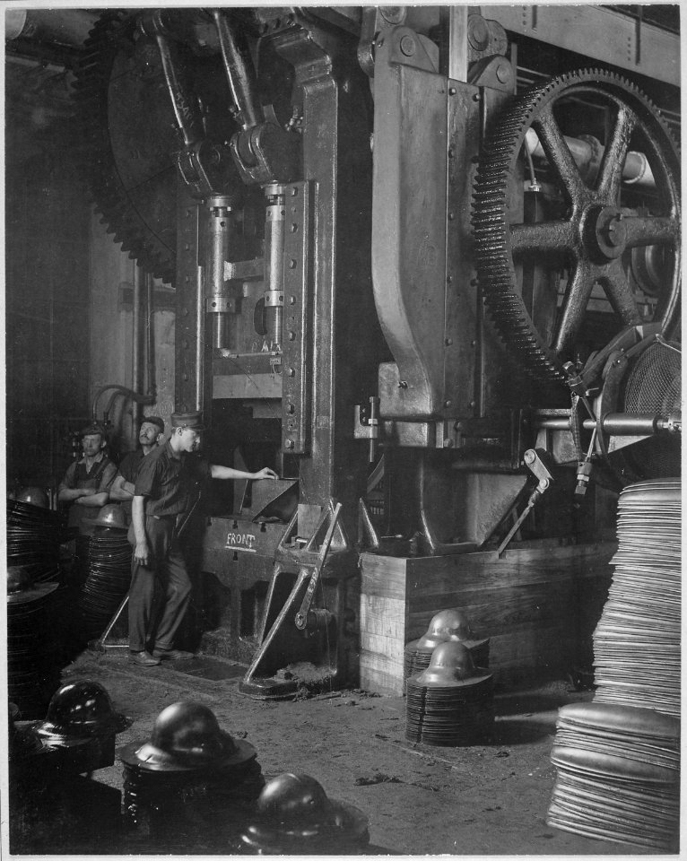 Manufacturing helmets. Large power press for shaping helmets in the plant of Hale & Kilburn Corporation, Philadelphia - NARA - 533469