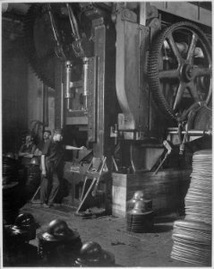 Manufacturing helmets. Large power press for shaping helmets in the plant of Hale & Kilburn Corporation, Philadelphia - NARA - 533469