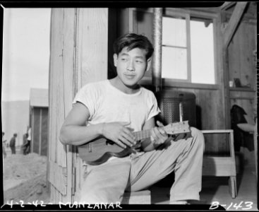 Manzanar Relocation Center, Manzanar, California. A uku (ukulele) affords amusement for young eva . . . - NARA - 536891