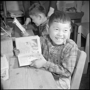 Manzanar Relocation Center, Manzanar, California. A pupil of the third grade is taught to read and . . . - NARA - 536698 photo