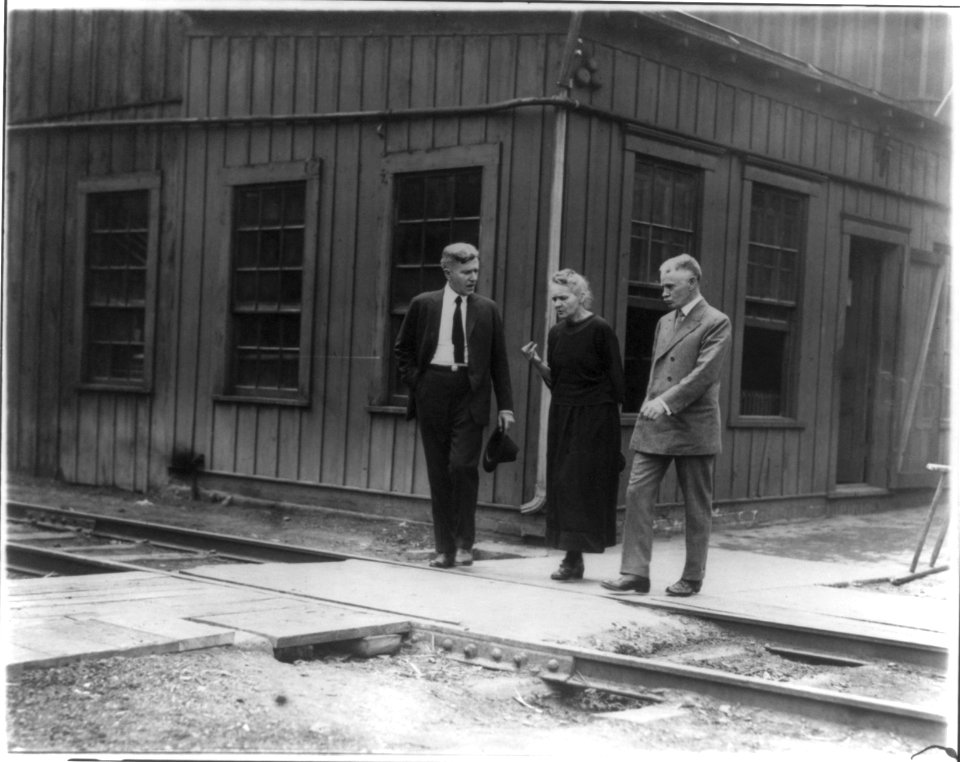 Marie Curie, 1867-1934, full-length portrait, standing between two men LCCN2005685548