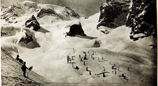 Marmolatascharte, links Punta Penia, rechts kleiner Vernel. In der Mulde eine Rinne, die ein vom Gletscher abgebrochener Eisblock gegraben hat. Die letzten Lärchen und Zirben, dazwischen Seilbahnständ (BildID 15585026)