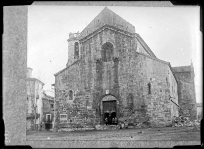 Plaça i monestir de Sant Pere de Besalú amb un grup de persones al portal (AFCEC VINTRO D 2843)
