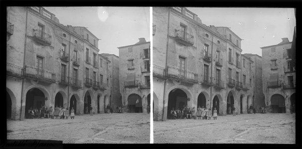 Plaça porxada de Castelló d'Empúries amb un grup de gent