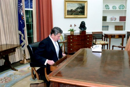 President Ronald Reagan checking his desk during his first day in the Oval Office