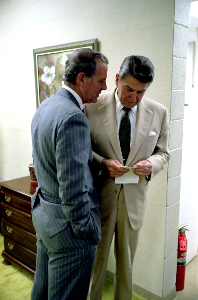President Ronald Reagan listening to James Baker