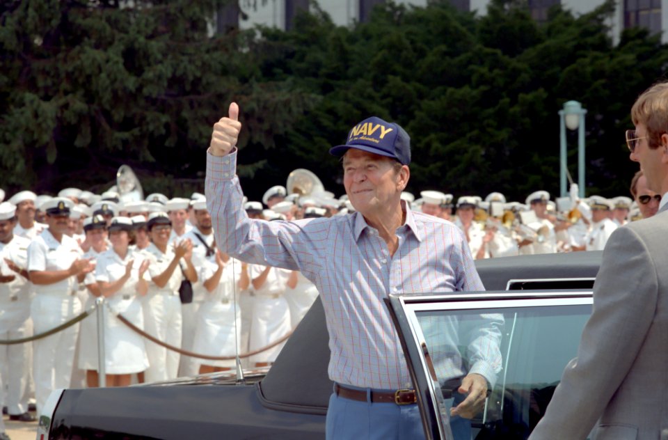 President Ronald Reagan gives the thumbs up sign while wearing a Navy hat upon departing from Bethesda Naval Medical Center in Maryland