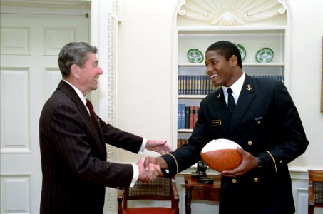 President Ronald Reagan during a photo opportunity with Napoleon McCallum Jr the star running back for the United States Naval Academy football team in the Oval Office photo