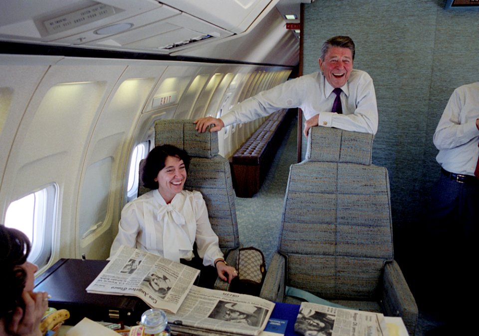 President Ronald Reagan laughing on Air Force One during a trip to California with Helene Von Damm