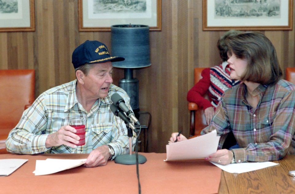 President Ronald Reagan making a radio address to the nation on international trade from Camp David with Elizabeth Board