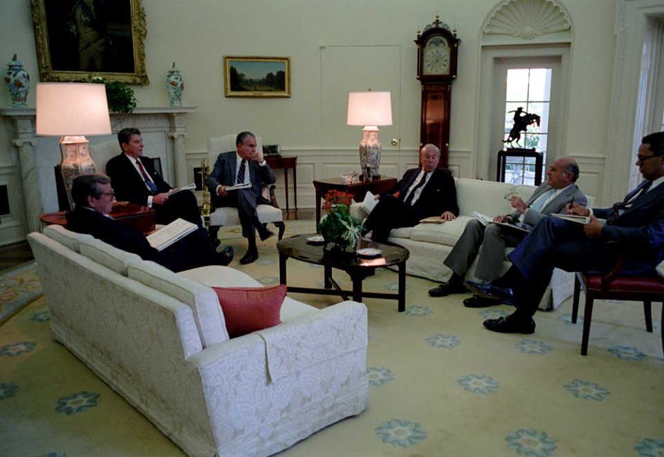 President Ronald Reagan during a meeting with Charles Wick, Marvin Stone, George Shultz, Colin Powell, and Howard Baker