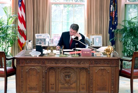 President Ronald Reagan during a telephone call to Congressman for lobbying at his desk in the Oval Office