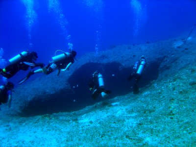 SCUBA divers approaching a sinkhole on a Guamanian reef (reef317083434) photo