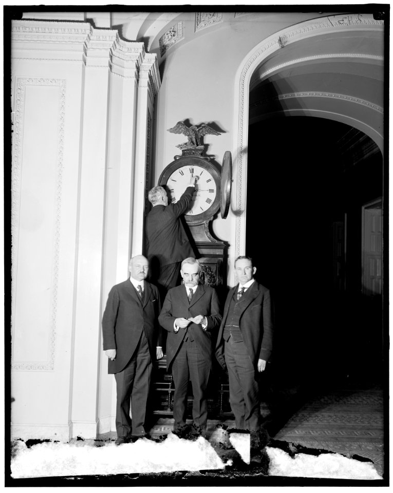 Senate Sergeant at Arms Charles Higgins turns forward the Ohio Clock for the first Daylight Saving Time, while Senators William Calder (NY), William Saulsbury, Jr. (DE), and Joseph T. LOC hec.13949