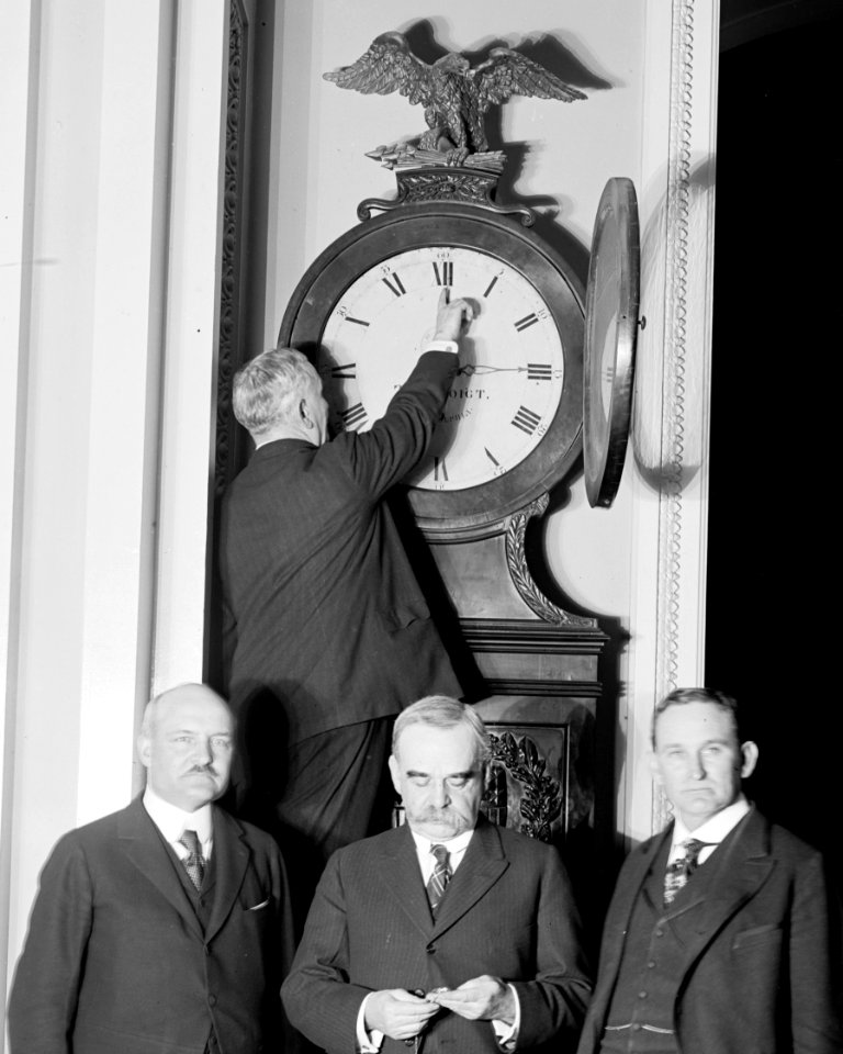Senate Sergeant at Arms Charles Higgins turns forward the Ohio Clock for the first Daylight Saving Time, while Senators William Calder (NY), William Saulsbury, Jr. (DE), and Joseph T. LOC hec.13949 (cropped)