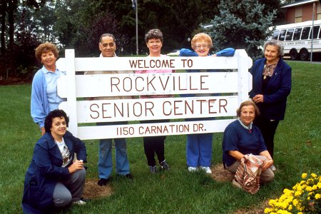 Senior citizens gathered around sign