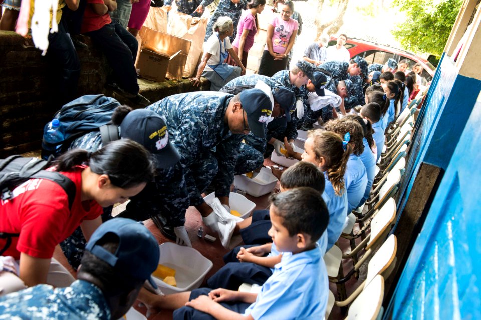 Service members and non-governmental organization volunteers wash children’s feet during Continuing Promise 2015. (19178643045)
