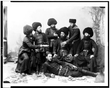 Seven men in Cossak costume, posing as if at a feast, Georgia (Republic LCCN92519215