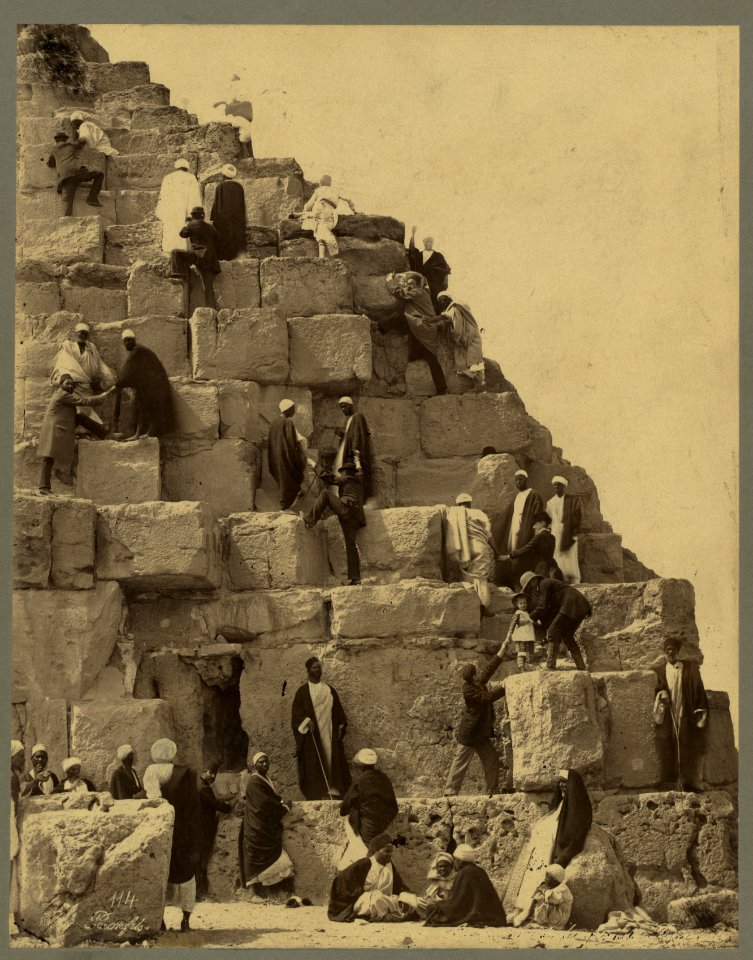 Several people gathered at the base of the Great Pyramid, others climbing) - Bonfils LCCN2004666751