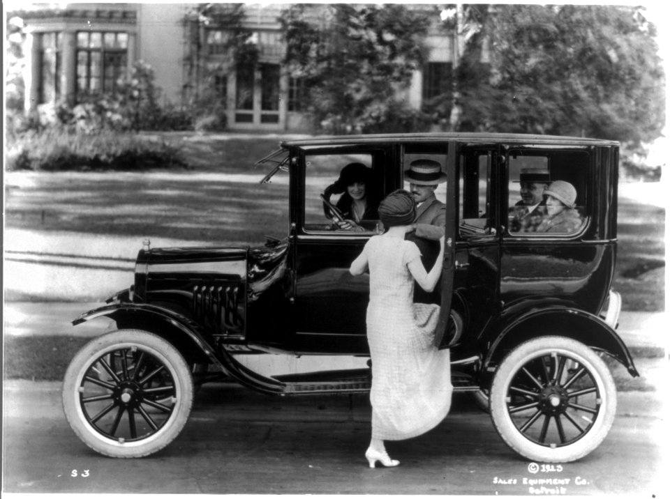 Side view of a Ford sedan with four passengers and a woman getting in on the driver's side LCCN95500789