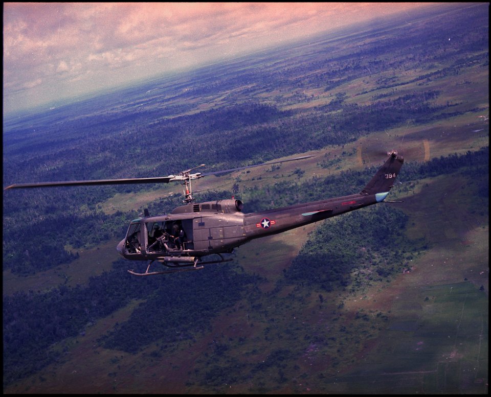 Side view of a Vietnamese Air Force UH-1H helicopter in flight over Southeast Asia. - NARA - 542344