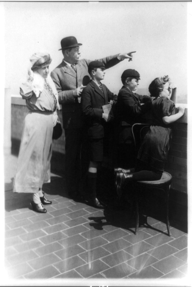Sir Arthur Conan Doyle and family looking over wall and pointing, New York City LCCN89714868