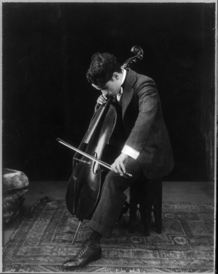 Sir Charles Chaplin, 1889-1977, full length portrait, seated, facing right; playing cello LCCN2005689014