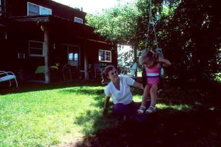 Sisters playing on a swing photo