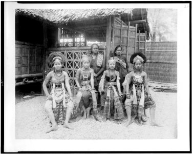 Six Javanese women, two in native dress, four in costume, full-length portrait, seated in front of Javanese dwelling, Paris Exposition, 1889 LCCN94500855