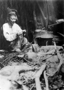 Skoltesame-kone, Tajana Feodotova Titoff, strikker ved kokestedet, antatt Sør-Varanger, Finnmark ca - Norsk folkemuseum - NF.06725-020