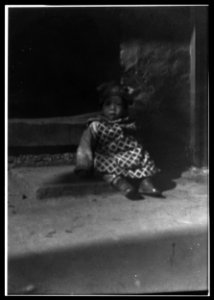 Small child sitting on a doorstep, Chinatown, San Francisco LOC agc.7a55035