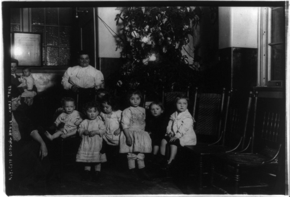 Small children in front of Christmas tree in New York City, lodging house LCCN2017656309