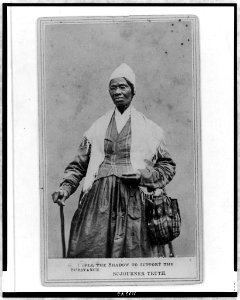 Sojourner Truth, three-quarter length portrait, standing, wearing spectacles, shawl, and peaked cap, right hand resting on cane LCCN97513239