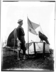 Soldier and eagle mascot beside H Troop flag LCCN96503331
