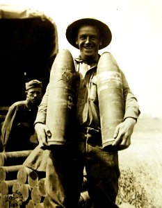 Soldier with 115 mm shells at ammunition dump, Montreuil-Aux-Lions, France, 1918 (30587928816)