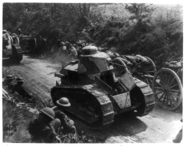 Soldiers and horse drawn caissons waiting at the side of a narrow road while tanks pass LCCN2017657350
