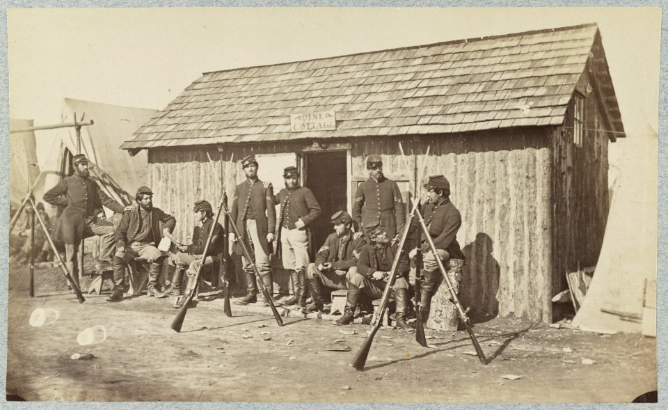 Soldiers outside a log cabin winter quarters, identified as Pine Cottage LCCN2013648700