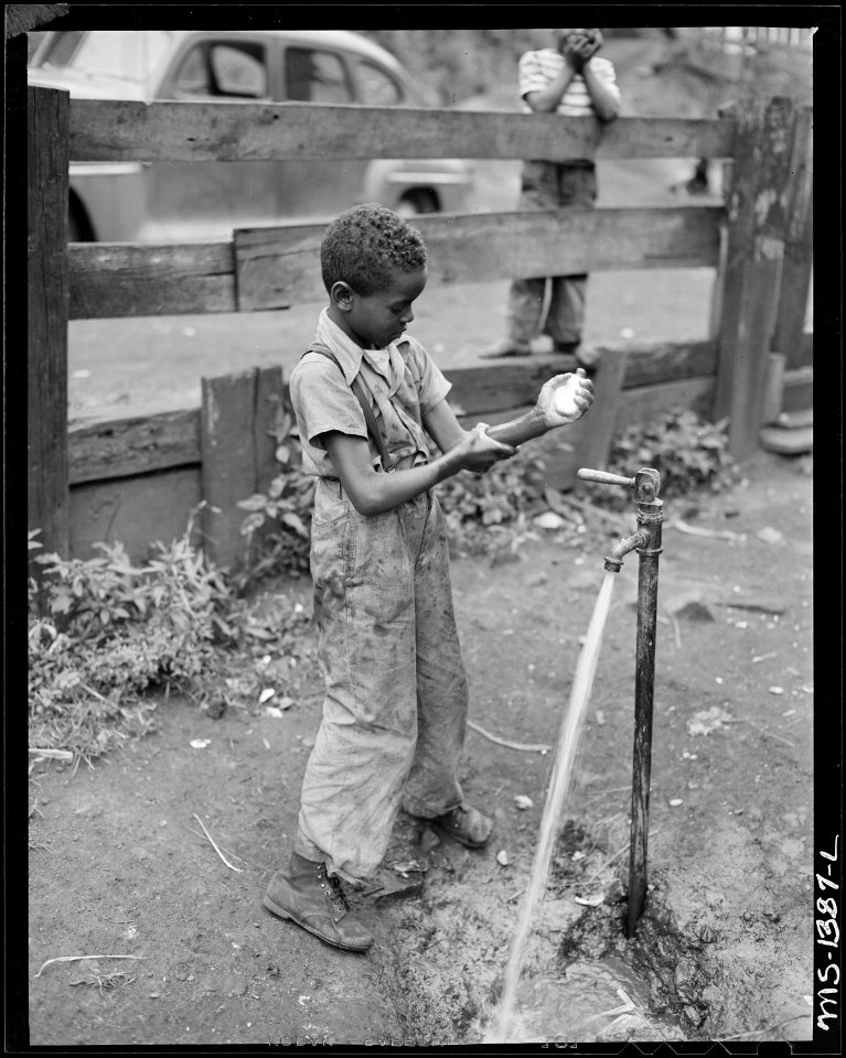 Son of James Robert Howard washes his hands before supper. Mr. Howard installed running water in his kitchen but... - NARA - 540778