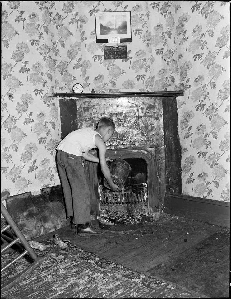 Son of Clabe Hicks, miner, builds fire in the grate. All heat is furnished by grate fires and kitchen range. Southern... - NARA - 541044