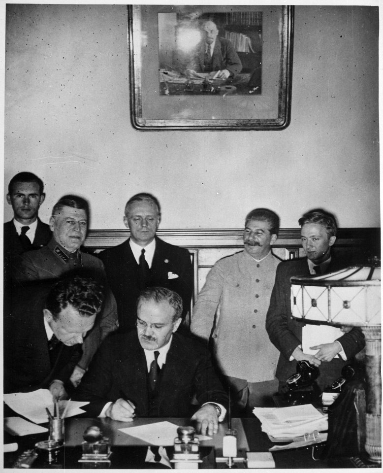 Soviet Foreign Minister Molotov signs the German-Soviet non-aggression pact, Joachim von Ribbentrop and Josef Stalin sta - NARA - 540196