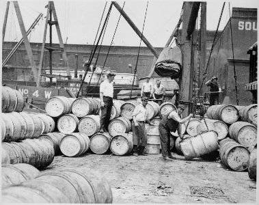 Stevedores on a New York Dock Loading Barrels of Corn Syrup onto a Barge on the Hudson River, ca. 1912 - NARA - 518287 photo