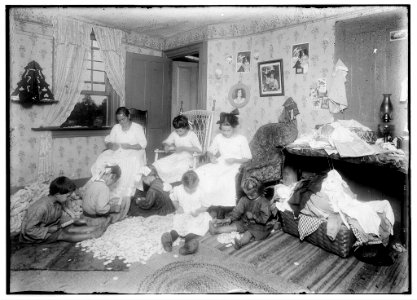 Stringing wooden buttons (button moulds) in a crowded home, Williamsburg, Mass. Mrs. Weeks and her children 13 years, 11 years, 7 years and her grand children 7 years, 5 years and 4 years LOC nclc.05501